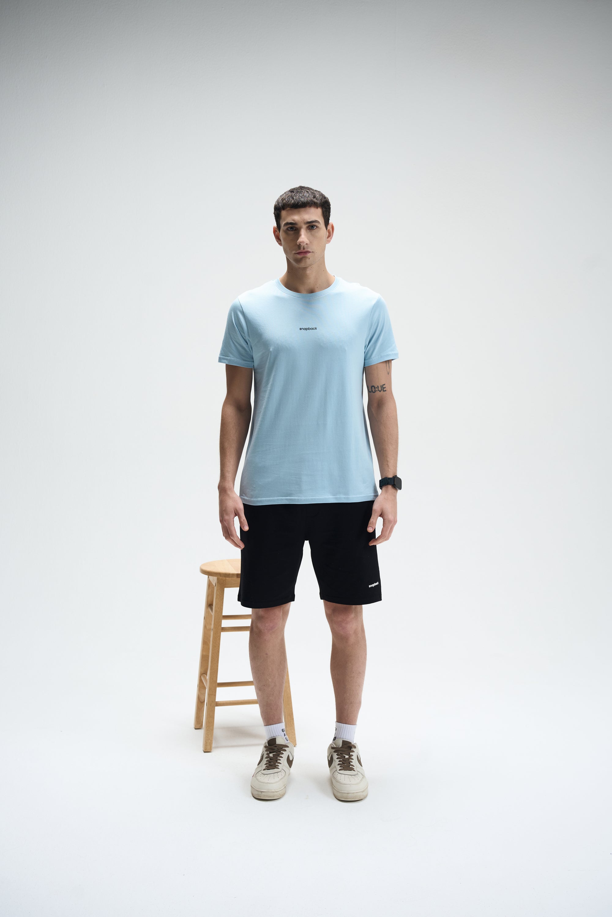 Men's powder blue SoftLuxe crew neck T-shirt with regular fit, styled with black shorts and sneakers.