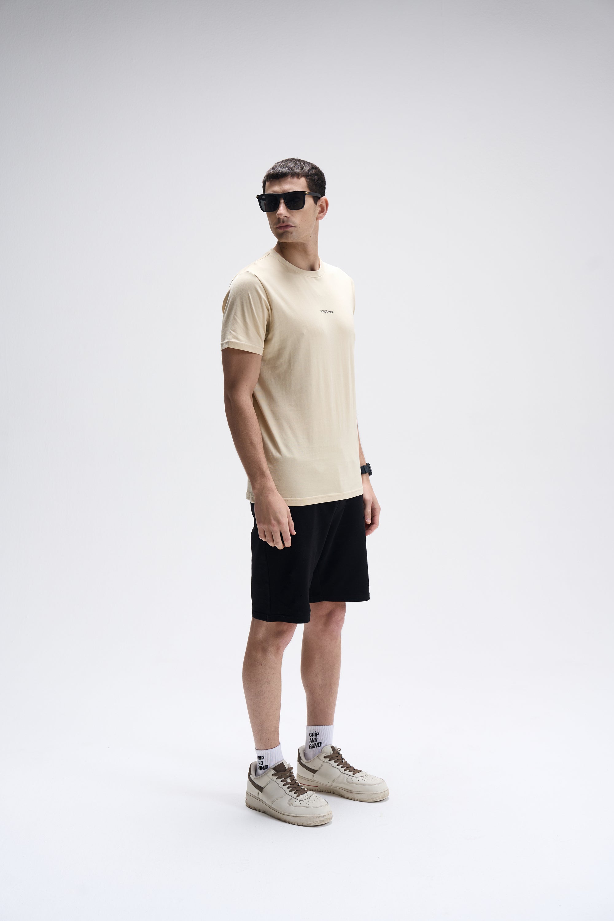 Men’s SoftLuxe Crew T-shirt in summer sand with regular fit, paired with black shorts and beige sneakers.